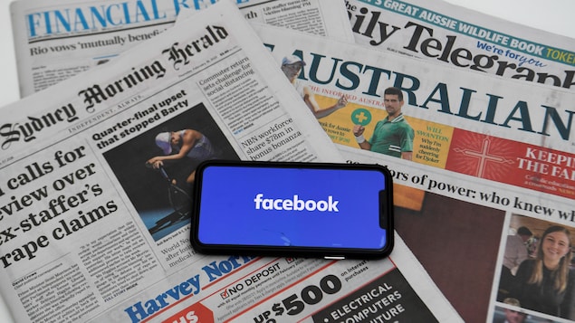 Des journaux avec un téléphone avec le logo Facebook