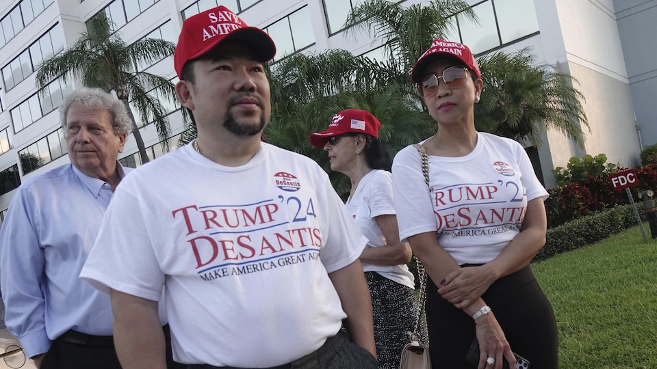In the front, two Republican supporters wear inscribed T-shirts. 