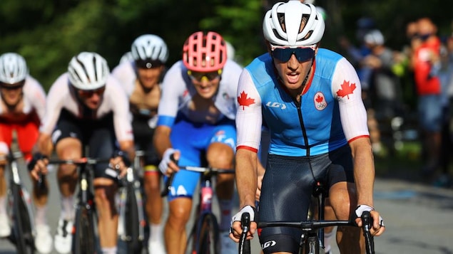 Canadian cyclist Michael Woods in front of a group of runners