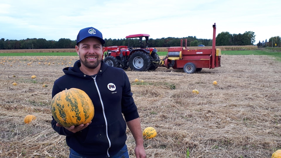 Sebastien Angers holding a pumpkin in his hand.