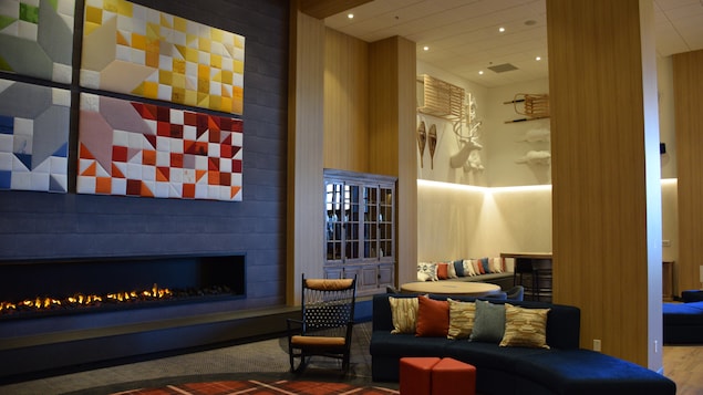 The hotel lobby has warm colors and a fireplace built into the wall