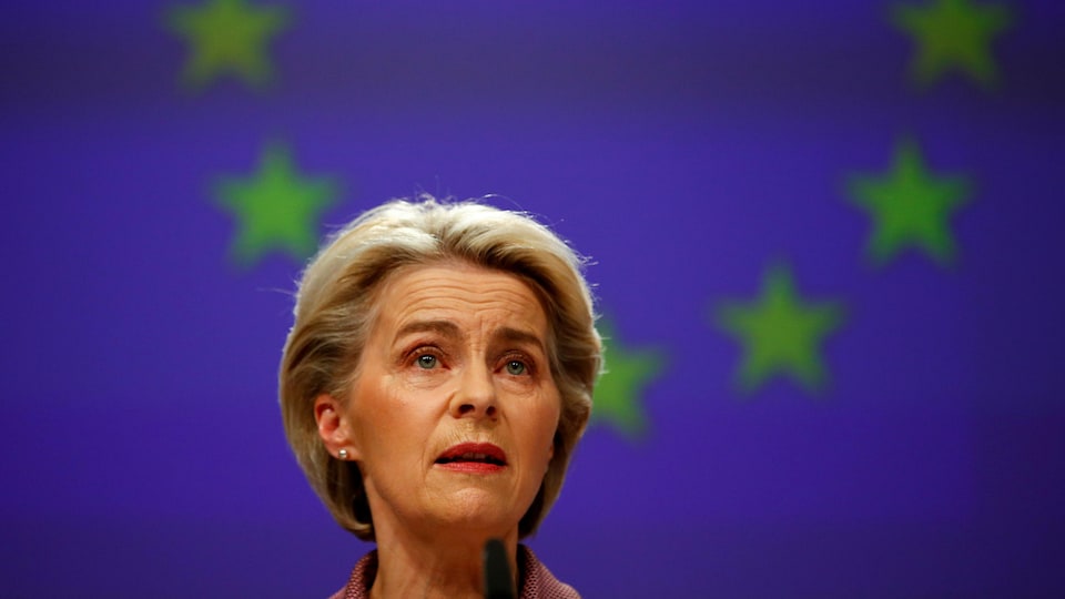 Ursula von der Leyen in front of the European Union flag.