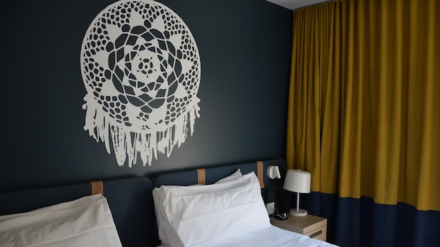 Two single beds next to each other with aboriginal-inspired motifs on the walls