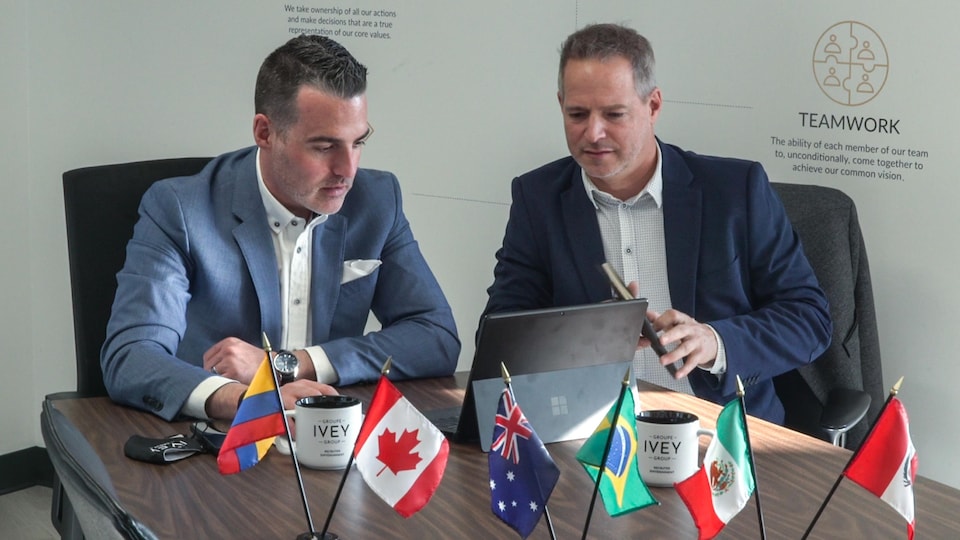 Anthony Lully and Patrice Dubrow were sitting next to each other at a table with several small flags on it