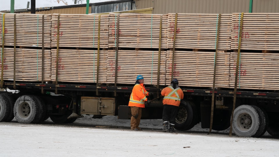 Two workers loading a truck 