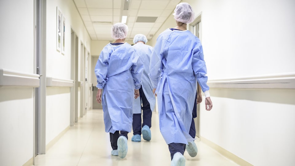 Nurses walk from behind in the hospital corridor.  
