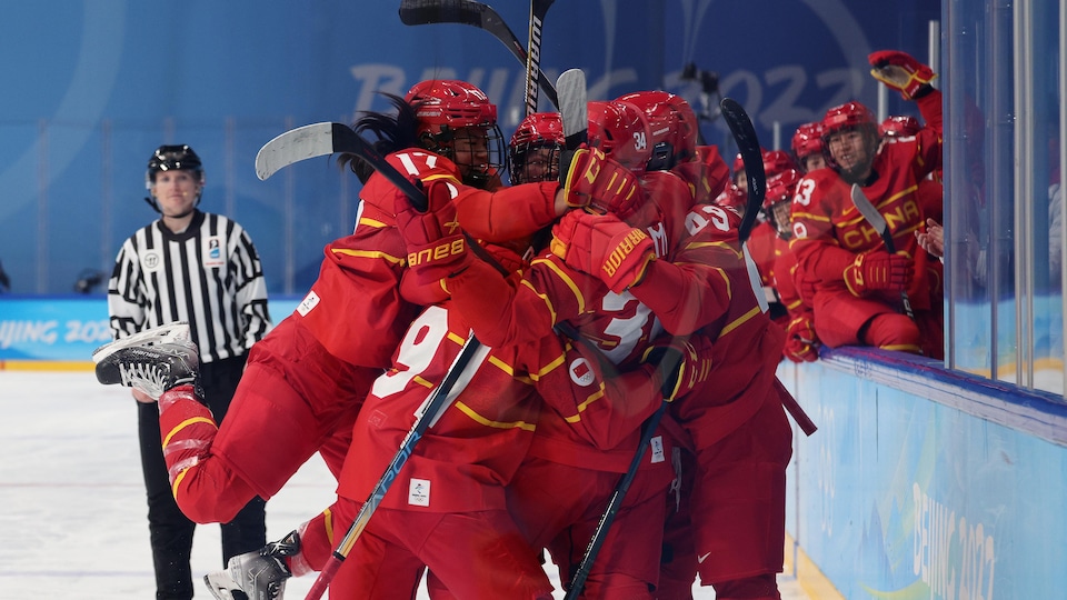 Hockey players celebrate the goal that was just scored.