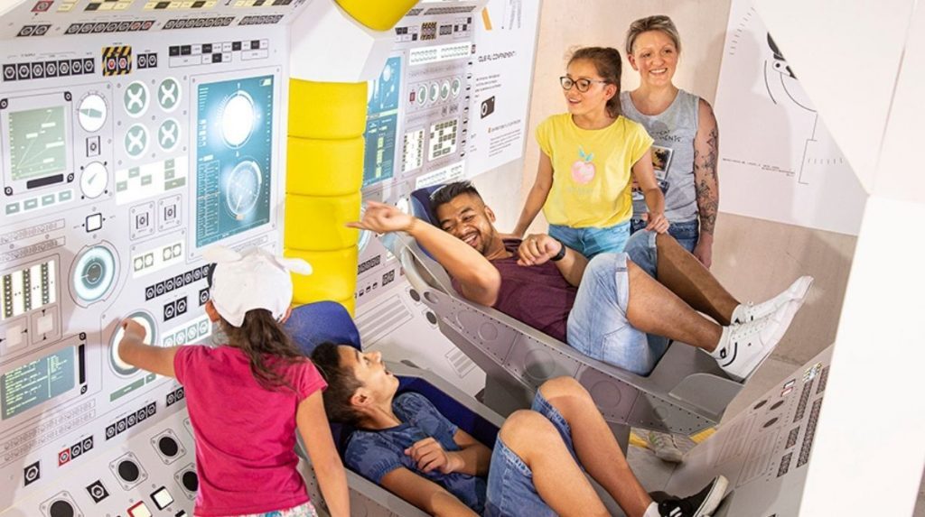 Visitors experience the take-off capsule seats as part of the entertainment offered in the queue to the Objectif Mars . attraction
