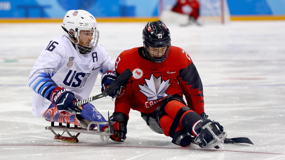 American Declan Farmer and Canadian Liam Hickey compete for possession of the puck in the final of the Paralympic Games in Pyeongchang.