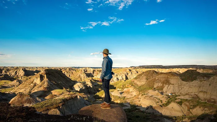 A person standing on a rocky outcrop notices the grooves that extend as far as the eye can see.