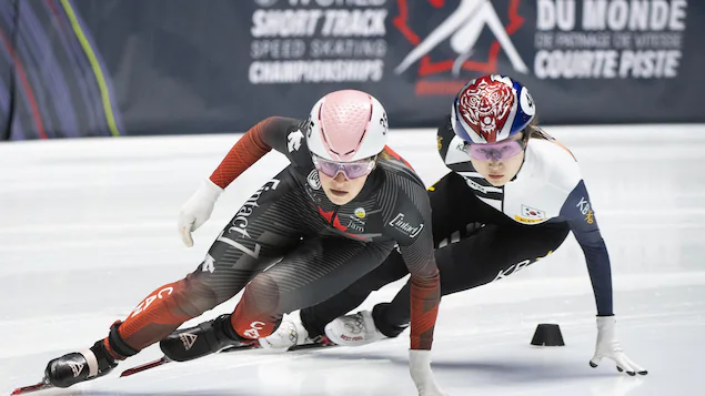She is ahead of a Korean skater during a turn.