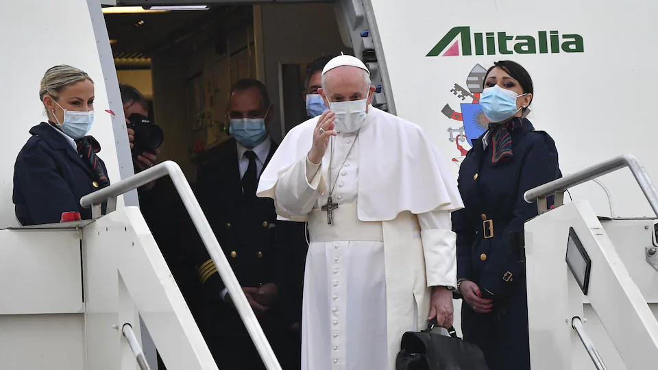 The Pope greets before entering the plane.