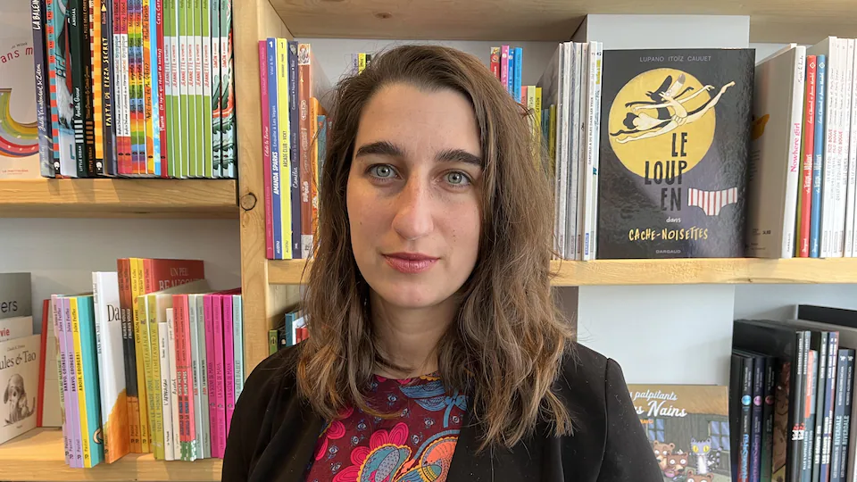 Émilise Lessard-Therrien in front of books in a bookstore.