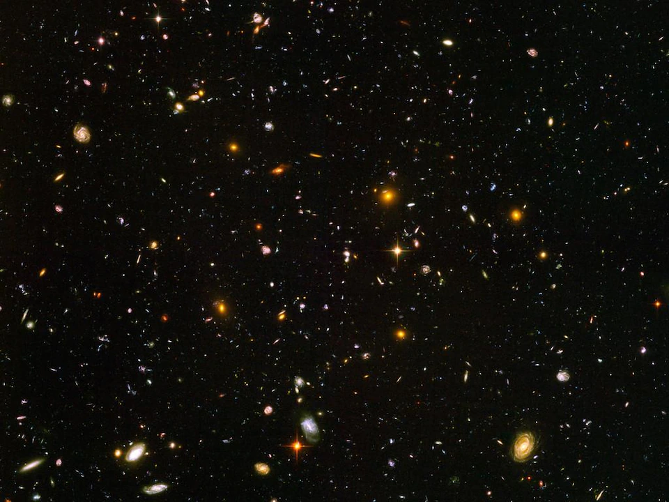 Hubble's ultra-deep field.  Many colored dots on a black background.