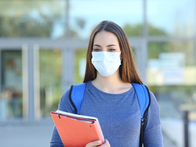 Une étudiante portant un masque pour se protéger de la COVID-19.