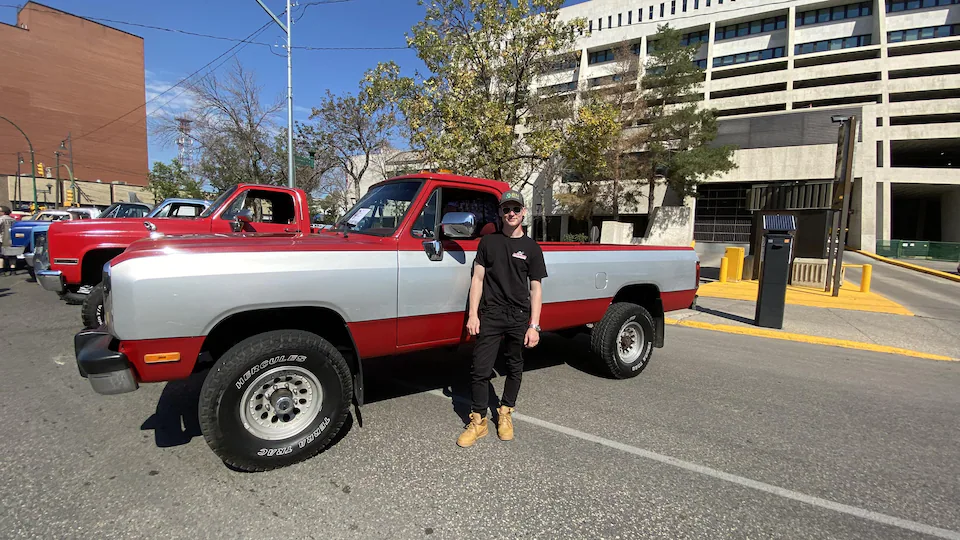 Jacob Waddell standing proudly in front of his truck. 