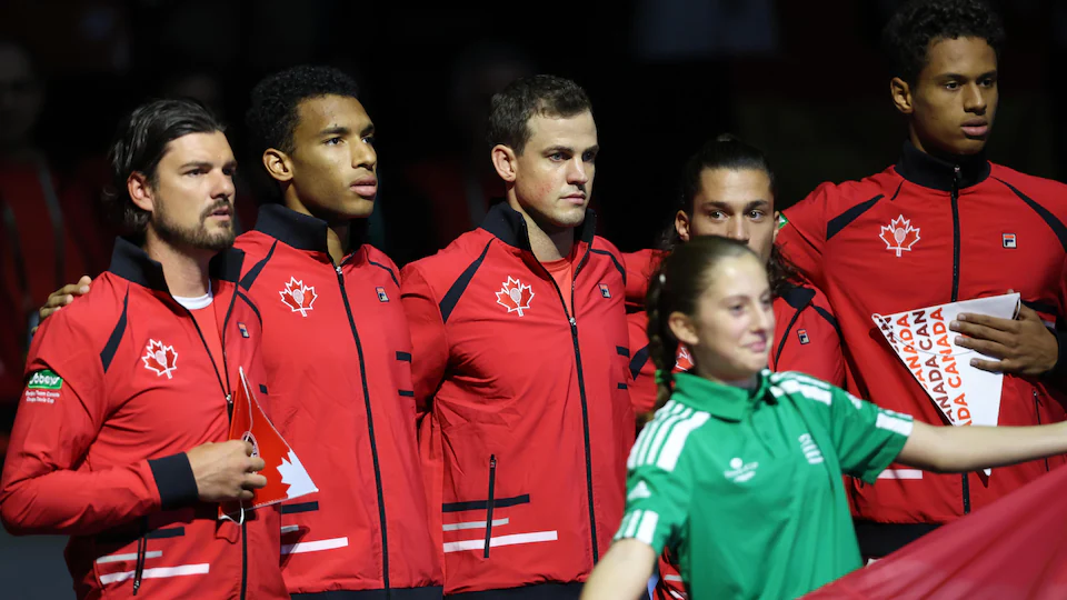 A captain poses with his four players before a tennis duel at the Davis Cup