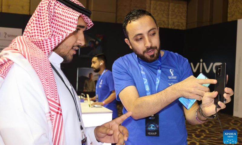 An employee shows a new smartphone to a visitor during the launch of its new Vivo product in Riyadh, Saudi Arabia, September 26, 2022. Chinese phone maker Vivo unveiled two 5G smartphones in Riyadh on Monday.  During the launch of new products in the Kingdom, Vivo introduced the latest additions to its V series of 5G smartphones: V25 and V25 Pro, which offer superior imaging.  (Photo: Xinhua)