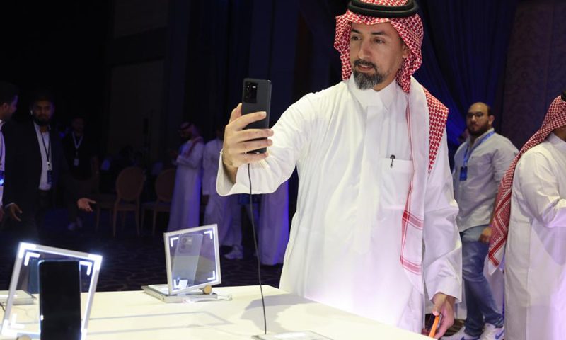 A visitor tries a new smartphone during the launch of new Vivo products in Riyadh, Saudi Arabia, September 26, 2022. Chinese phone maker Vivo unveiled two 5G smartphones in Riyadh on Monday.  During the launch of new products in the Kingdom, Vivo introduced the latest additions to its V series of 5G smartphones: V25 and V25 Pro, which offer superior imaging.  (Photo: Xinhua)