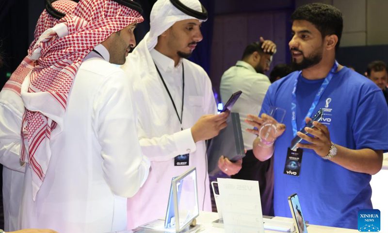 An employee displays a new smartphone to visitors during the launch of its new Vivo product in Riyadh, Saudi Arabia, September 26, 2022. Chinese phone maker Vivo unveiled two 5G smartphones in Riyadh on Monday.  During the launch of new products in the Kingdom, Vivo introduced the latest additions to its V series of 5G smartphones: V25 and V25 Pro, which offer superior imaging.  (Photo: Xinhua)