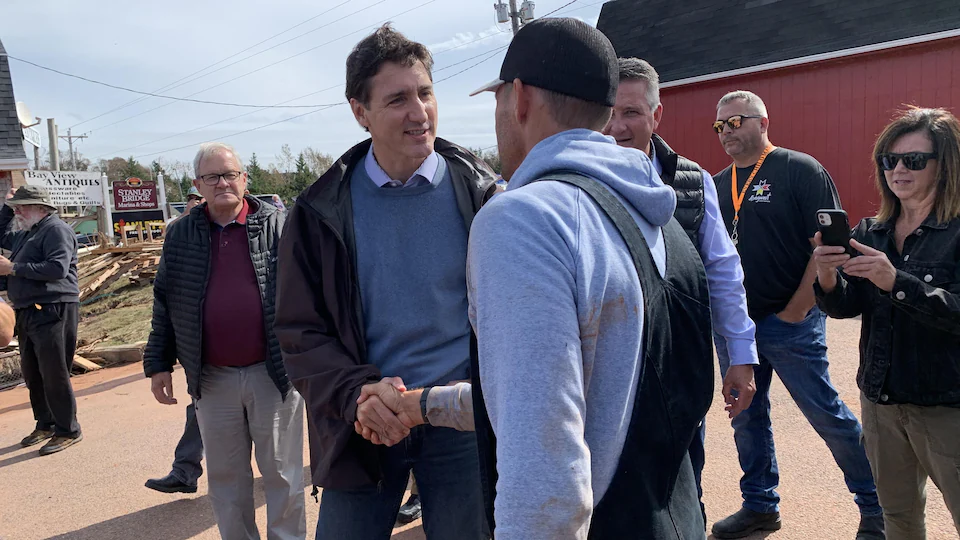 Justin Trudeau shakes hands with a worker.